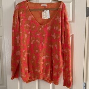 Stylish V-Neck Sweater in Vibrant Coral Orange and Tan Animal Print